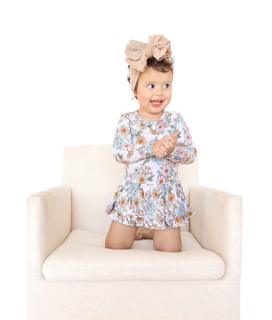 Baby skirted bodysuit with flowers and ruffles. Twirl dress