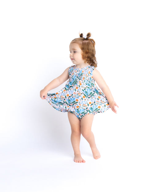 Shop our bamboo smocked romper with a skirted design for babies in a blue and pink spring floral print. Eco-friendly and breathable for all-day comfort.