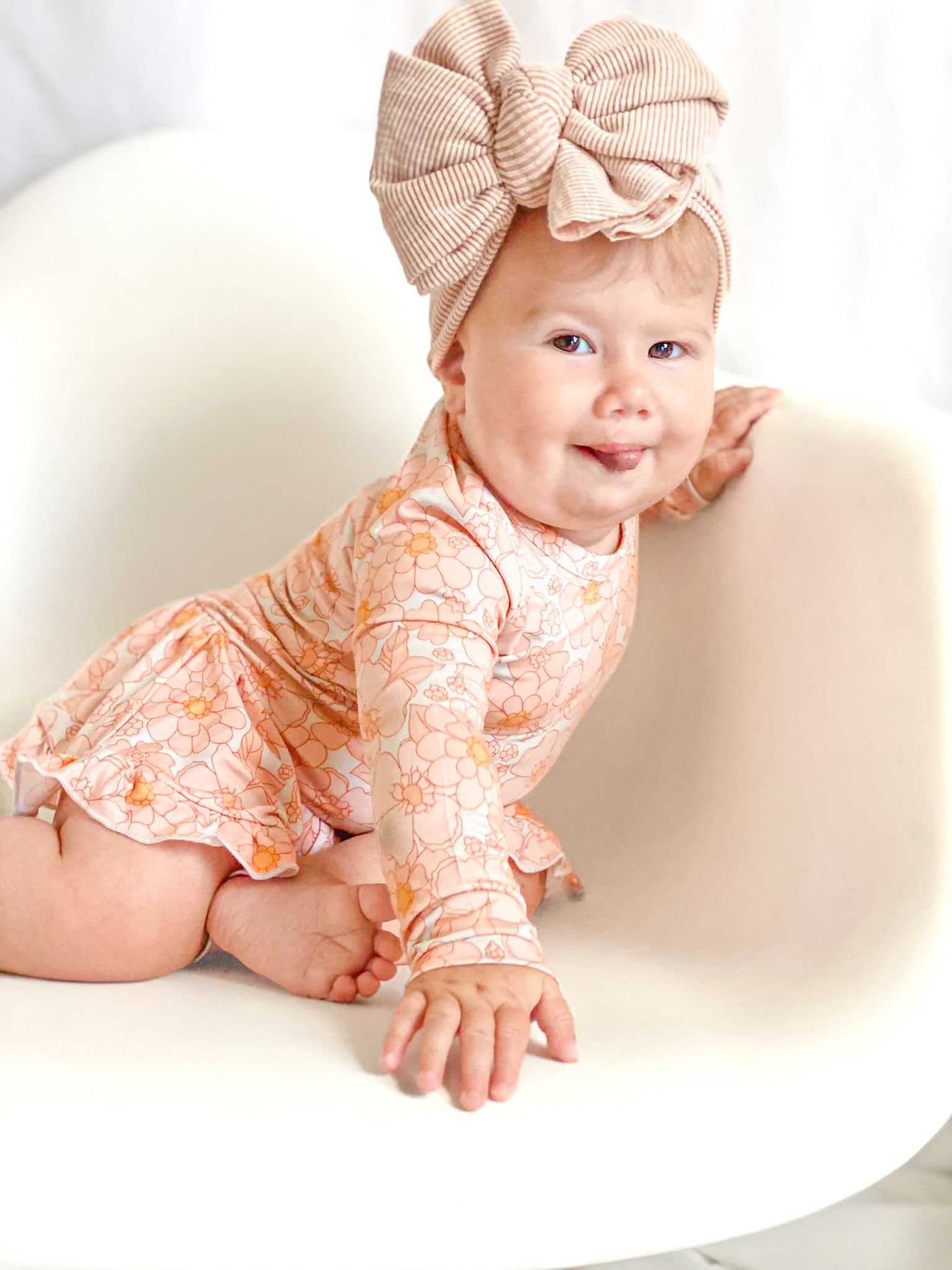 Baby wearing a floral skirted bodysuit.