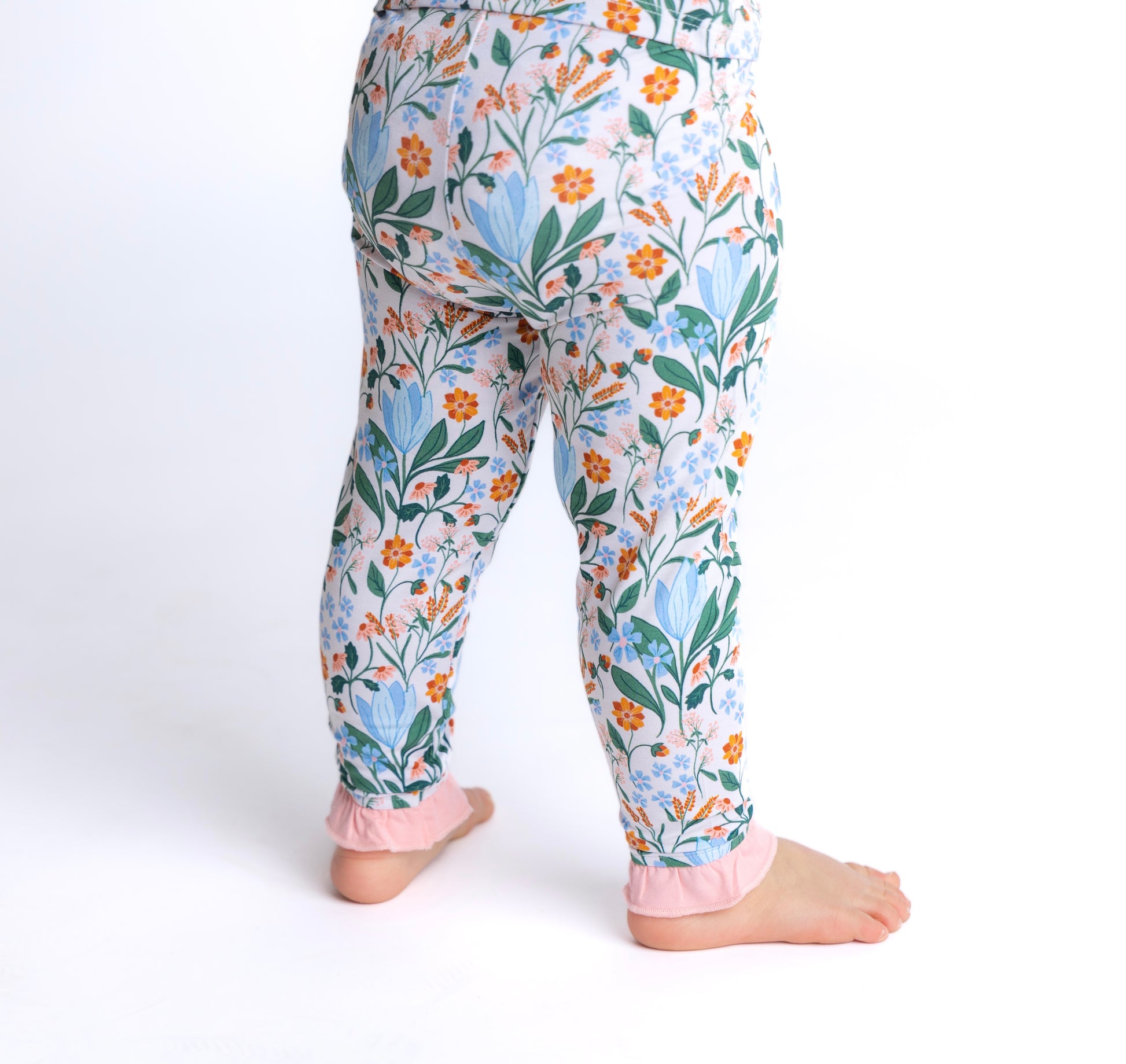 Shop our bamboo two-piece pajama set for toddlers and kids in a soft blue and pink spring floral print, complete with cute ruffle details. Eco-friendly, breathable fabric ensures comfort all night long.