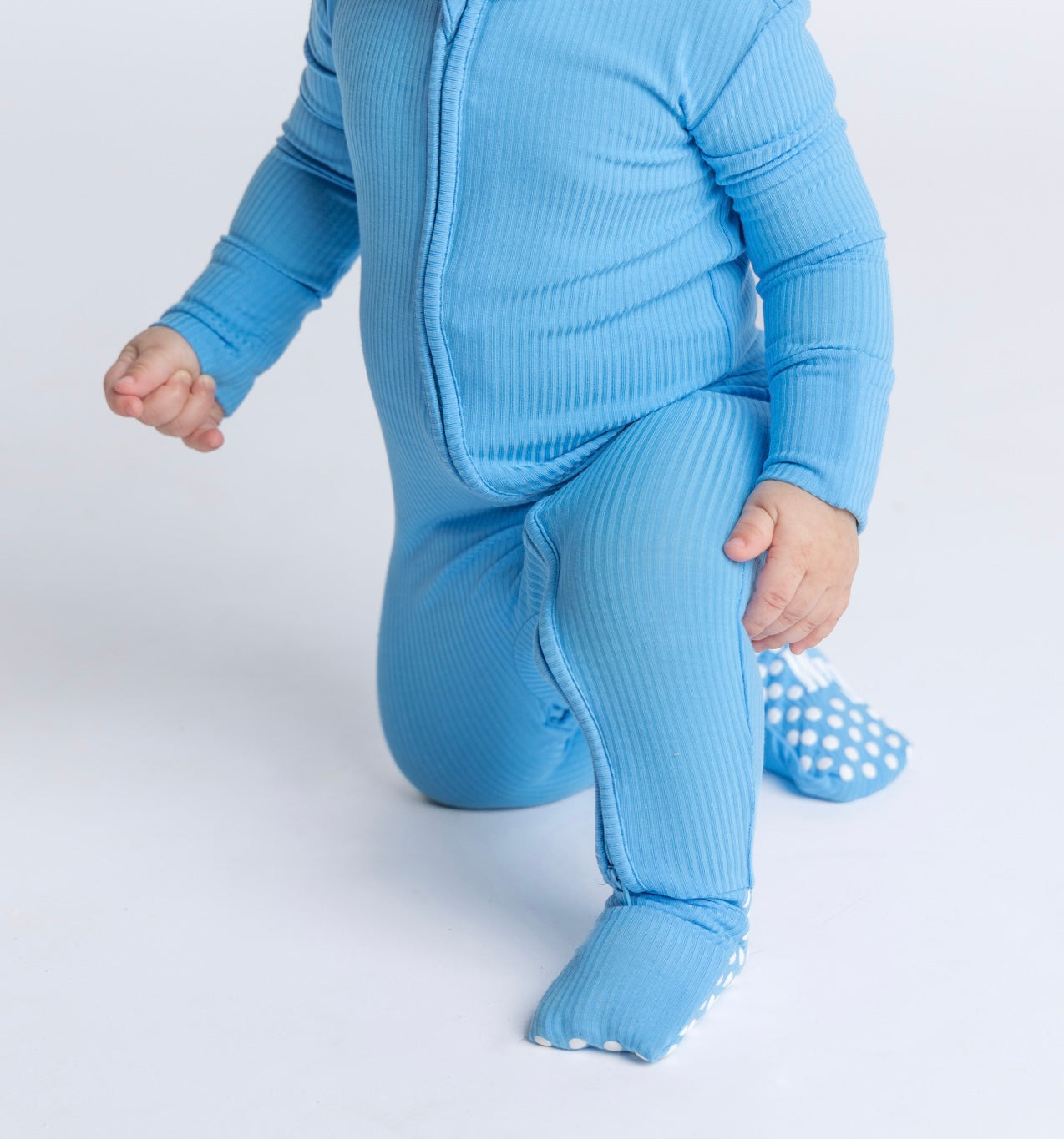 Blue ribbed bamboo convertible sleeper footie for babies, crafted from soft, breathable, and eco-friendly bamboo fabric for maximum comfort and convenience. Perfect for little ones!