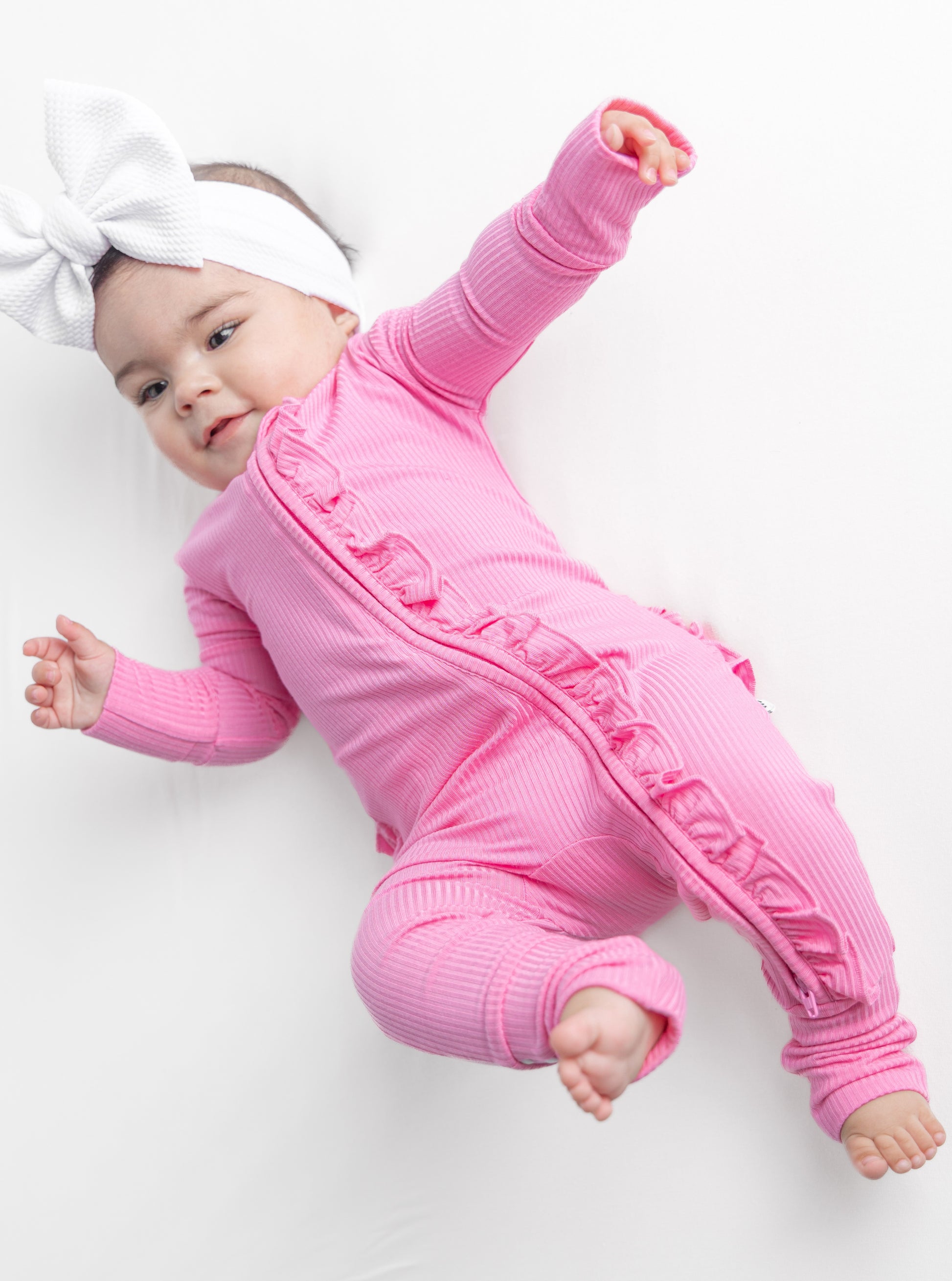 Baby girl wearing pink bamboo pajamas.