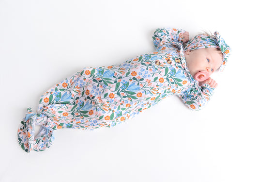 Bamboo newborn gown and bow set in a beautiful spring floral print with soft blue and pink flowers. Made from eco-friendly, breathable fabric for ultimate comfort.