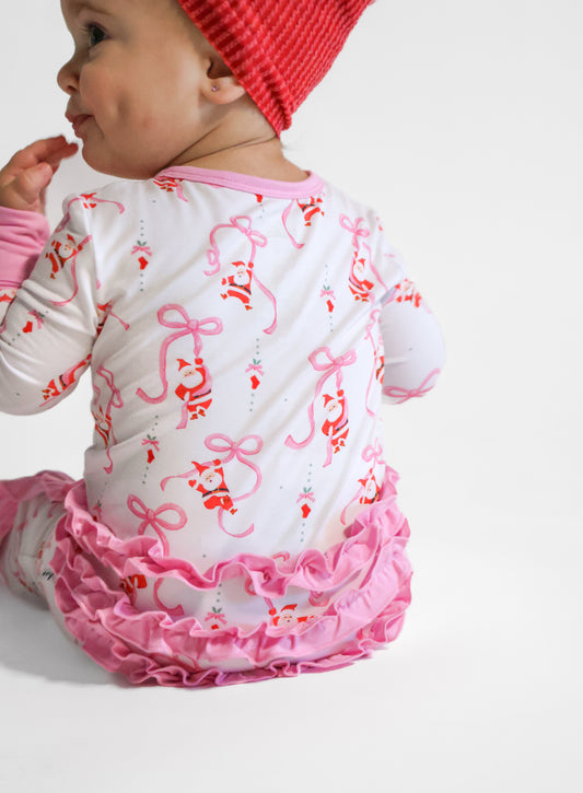 Baby wearing Christmas bamboo zippy with pink bows and santa.