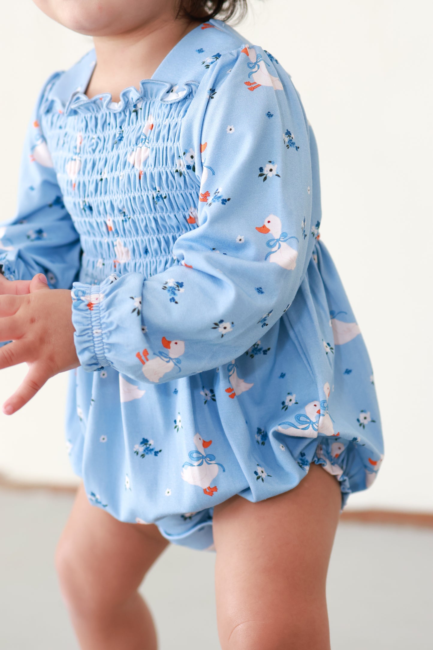 child wearing blue duck bamboo smocked bubble romper