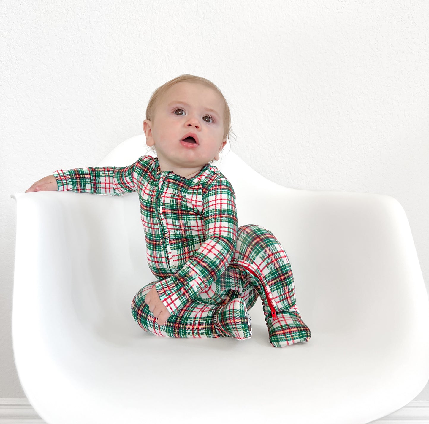 Baby in a cozy classic Christmas plaid print bamboo convertible zip romper, perfect for the holiday season. Made from Bamboo Viscose.