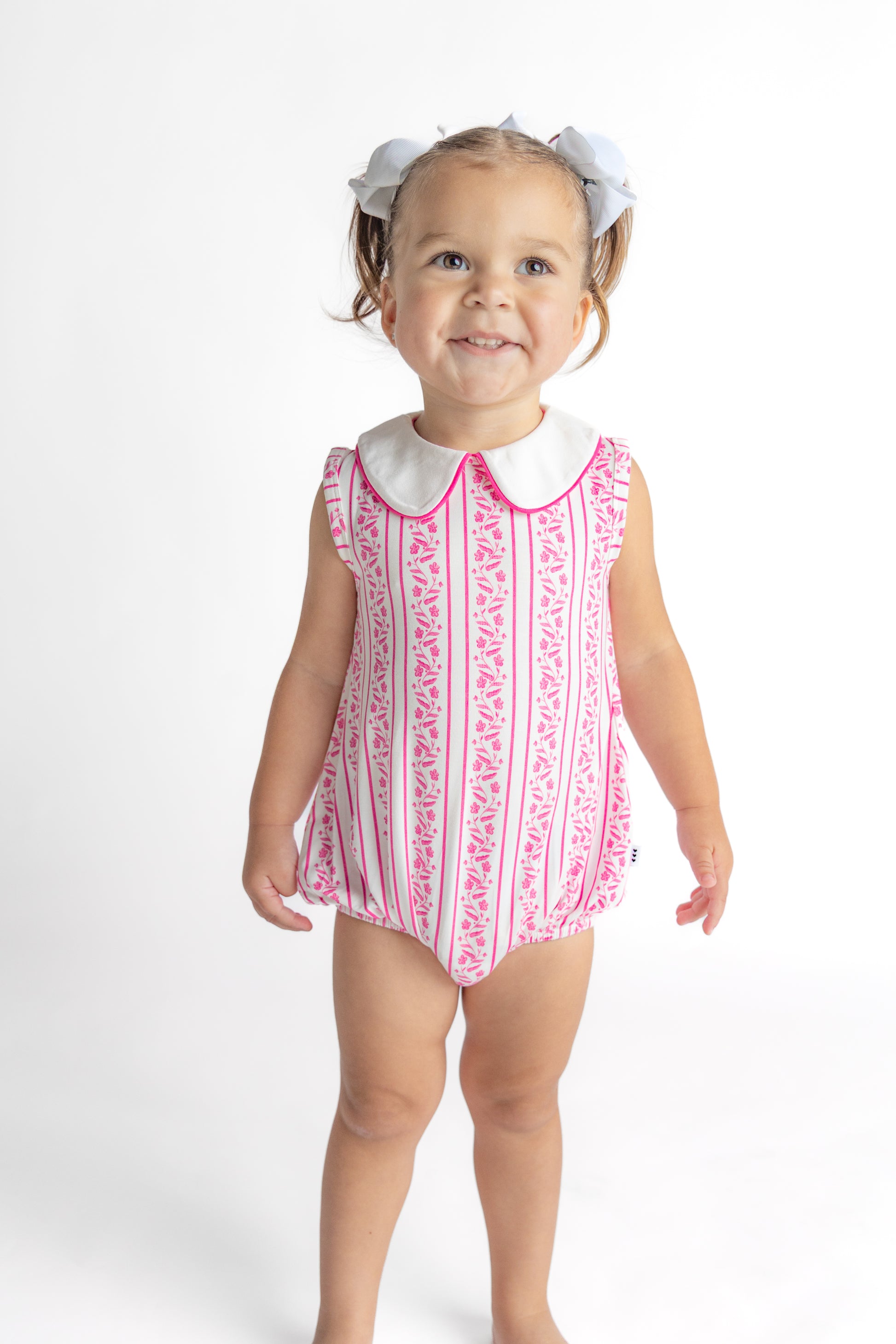 Infant in a pink floral patterned bamboo bubble romper made of soft viscose fabric