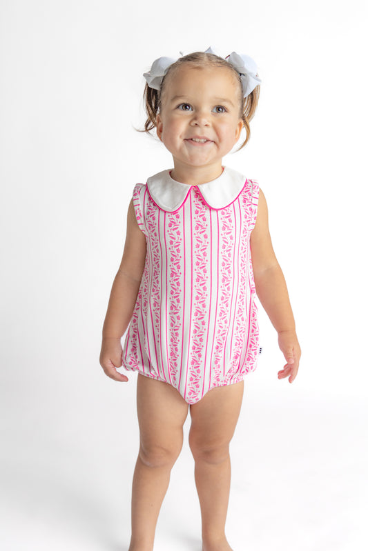 Infant in a pink floral patterned bamboo bubble romper made of soft viscose fabric