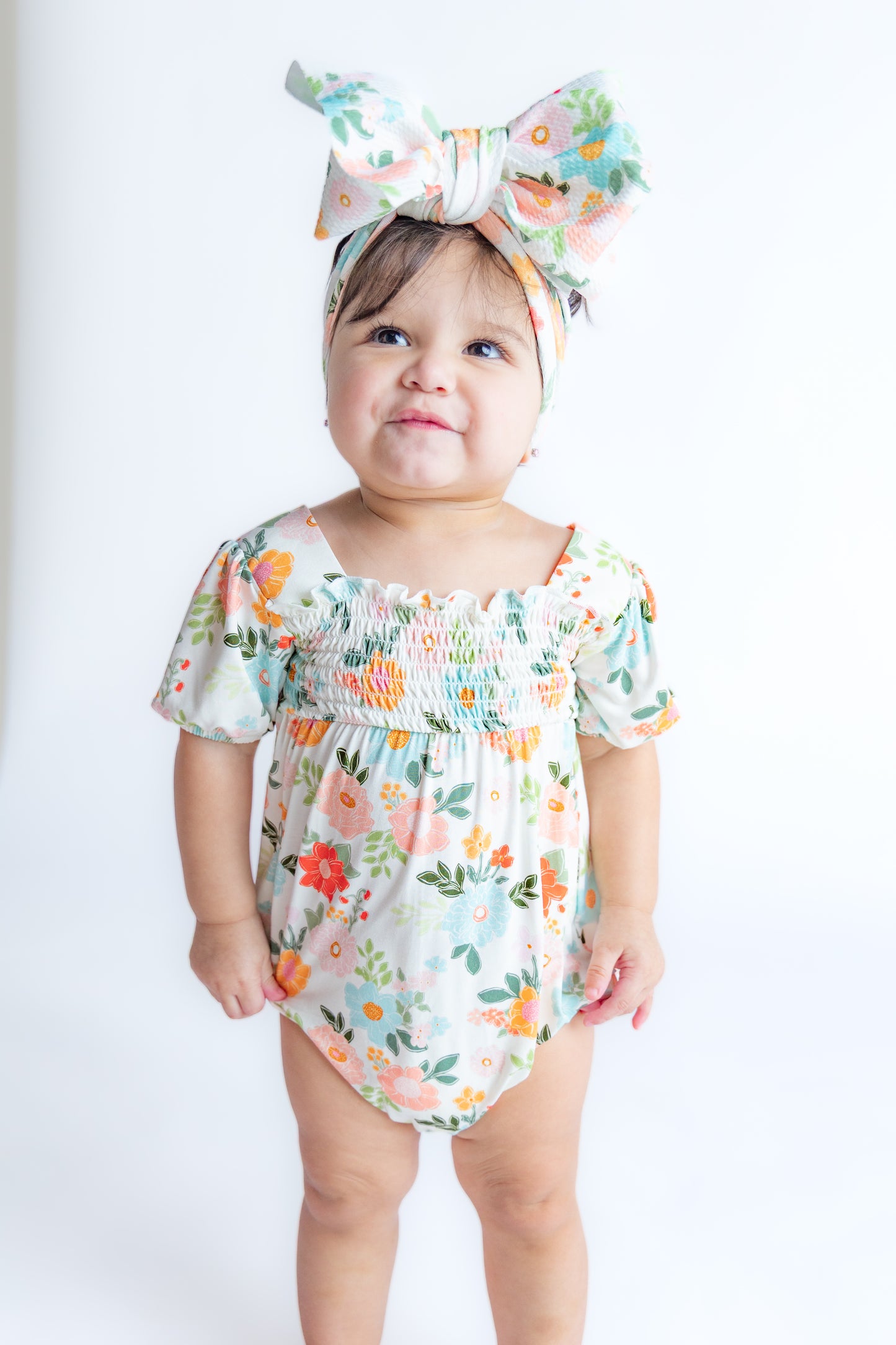 Baby girl wearing floral smocked bubble romper.