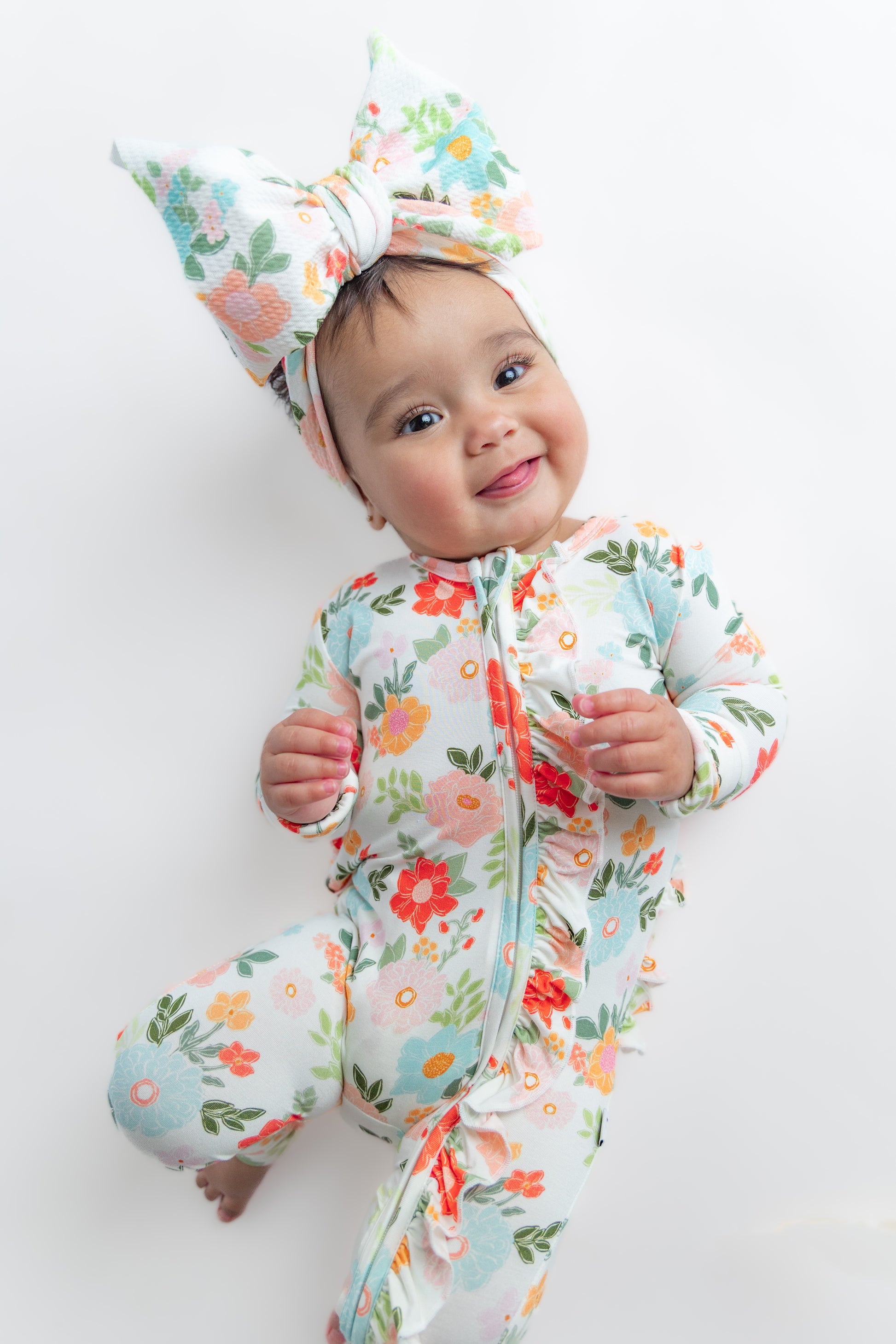 Baby wearing floral bamboo sleeper and headwrap bow
