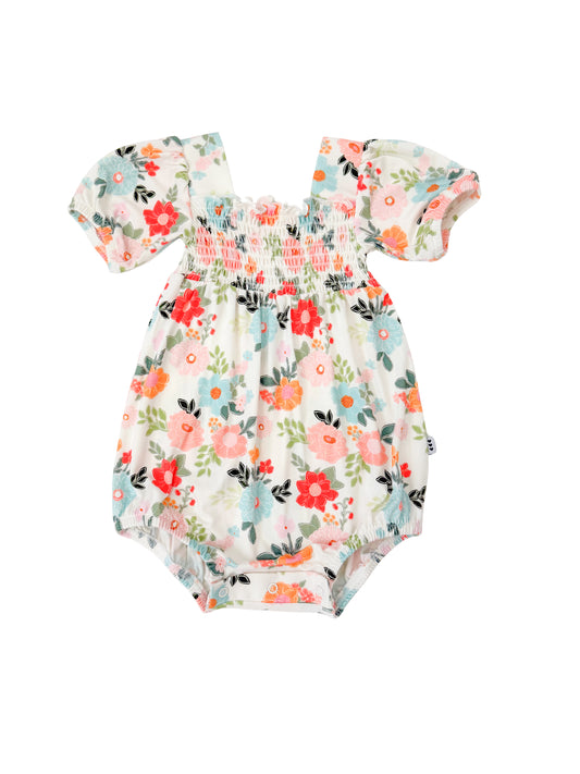 Floral smocked bubble romper on white background.