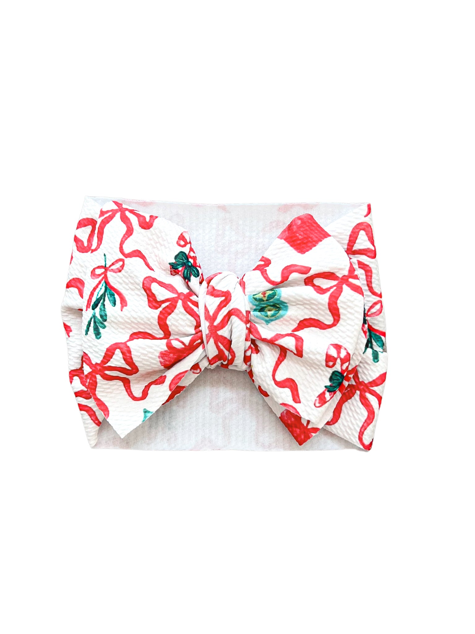 Festive Noelle baby headwrap bow featuring a Christmas print with bows and candy canes, perfect for the holidays.