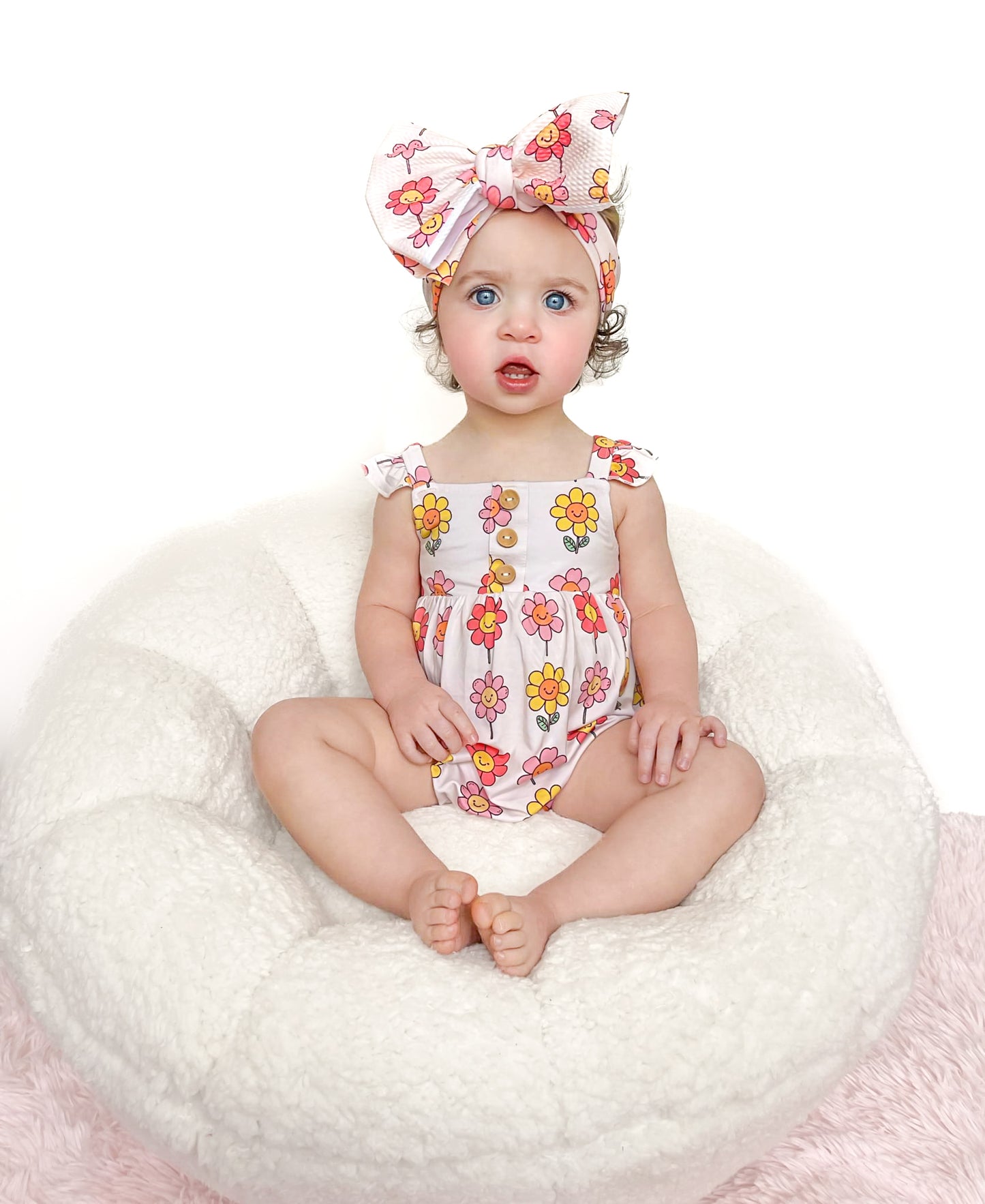 Bright and cheerful bamboo romper with a smiling daisy flower print, perfect for girly girls, paired with matching bamboo daywear and pajamas.