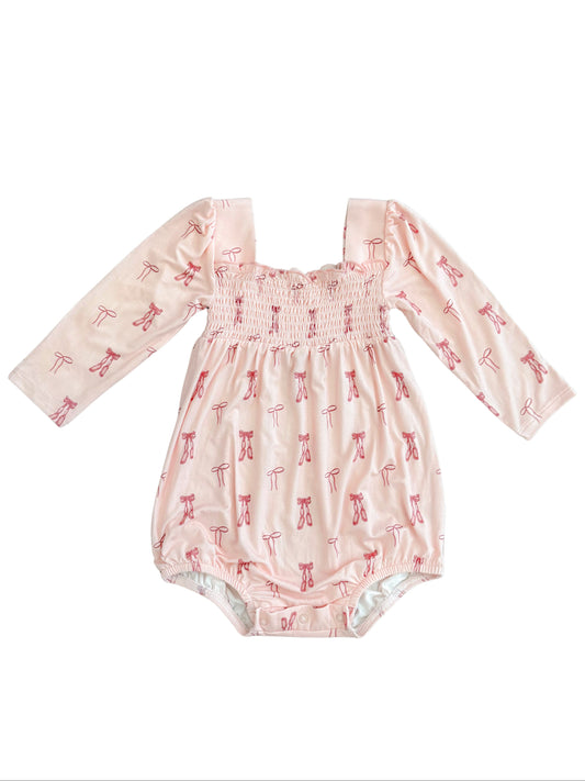 Smocked bubble romper for baby girl featuring print with ballet shoes and bows. 