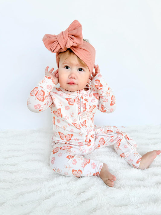 Baby girl bamboo pajama footie featuring a butterfly floral print. Soft and cozy baby bamboo.