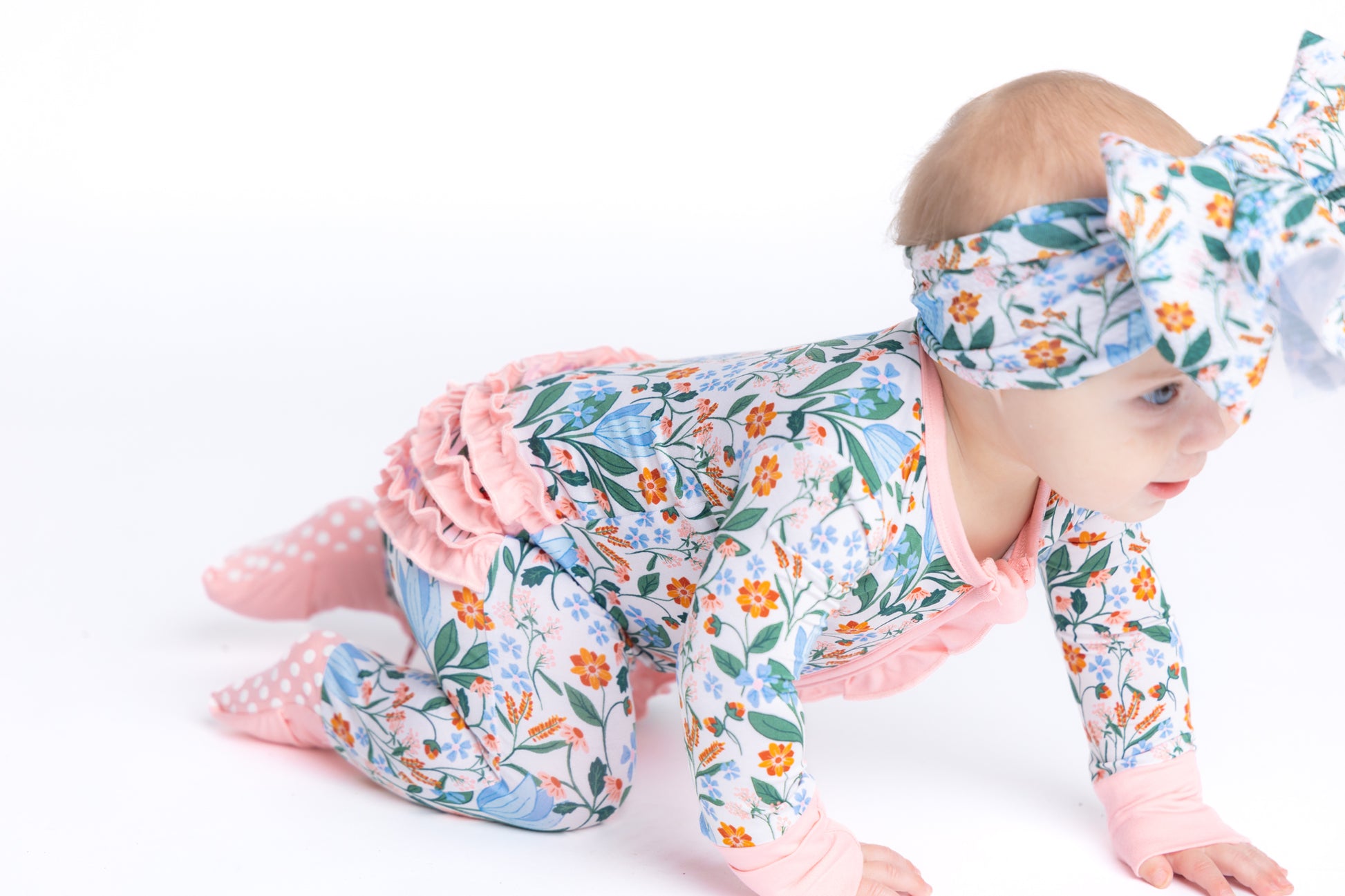 Bamboo convertible zip romper for babies in a blue and pink spring floral print. Eco-friendly and breathable fabric for easy changes and all-day comfort.