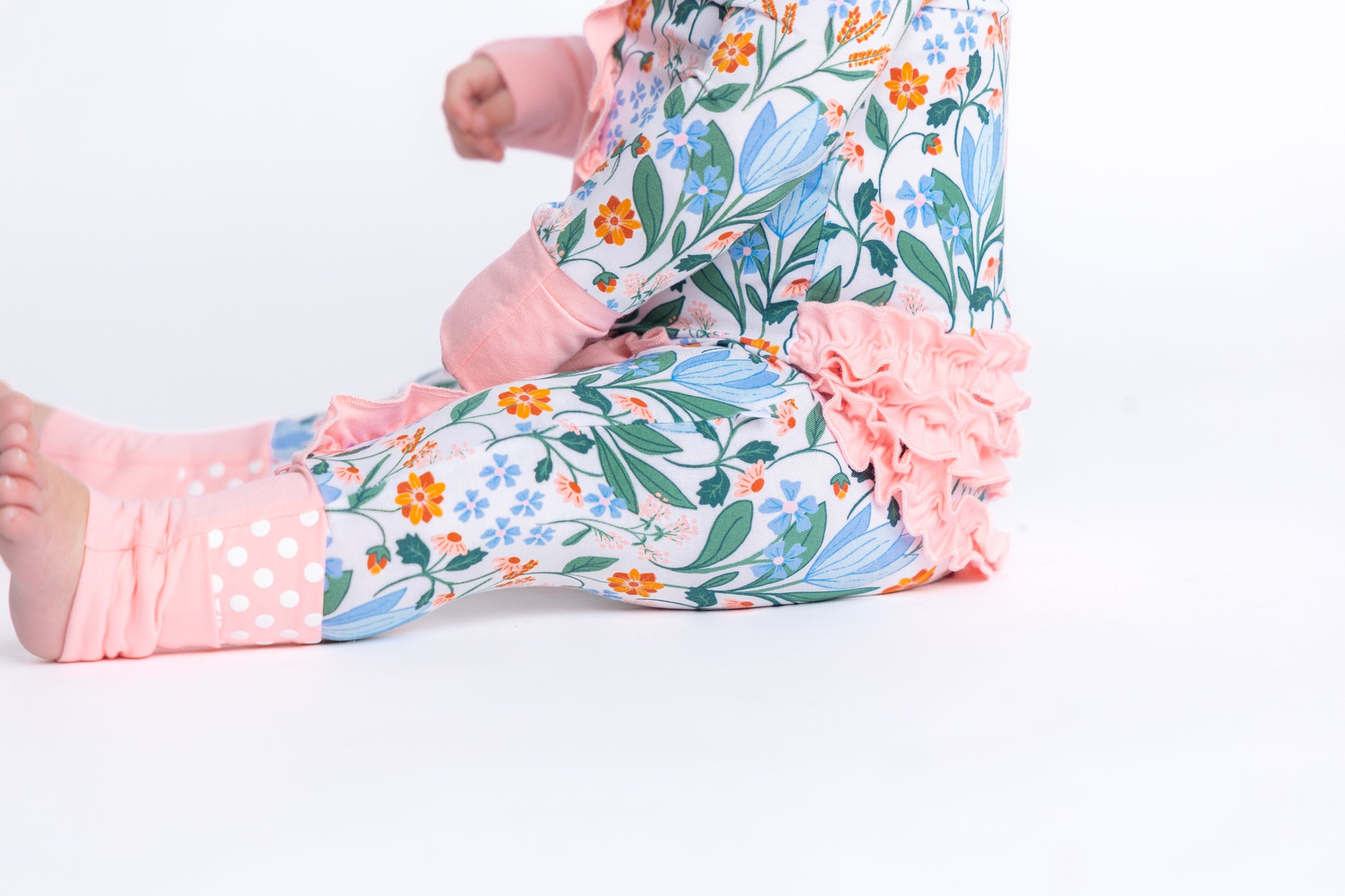 Bamboo baby sleeper with a double zipper in a blue and pink spring floral print. Eco-friendly and breathable for easy changes and all-day comfort. Shop now!