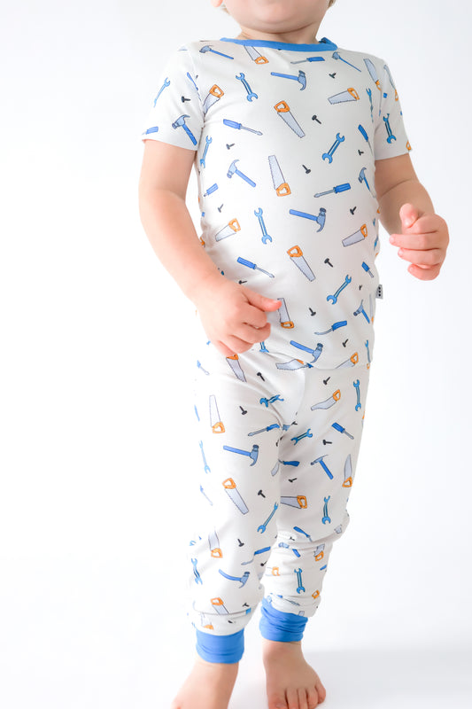 Child wearing a bamboo pajama set with tool pattern on a white background