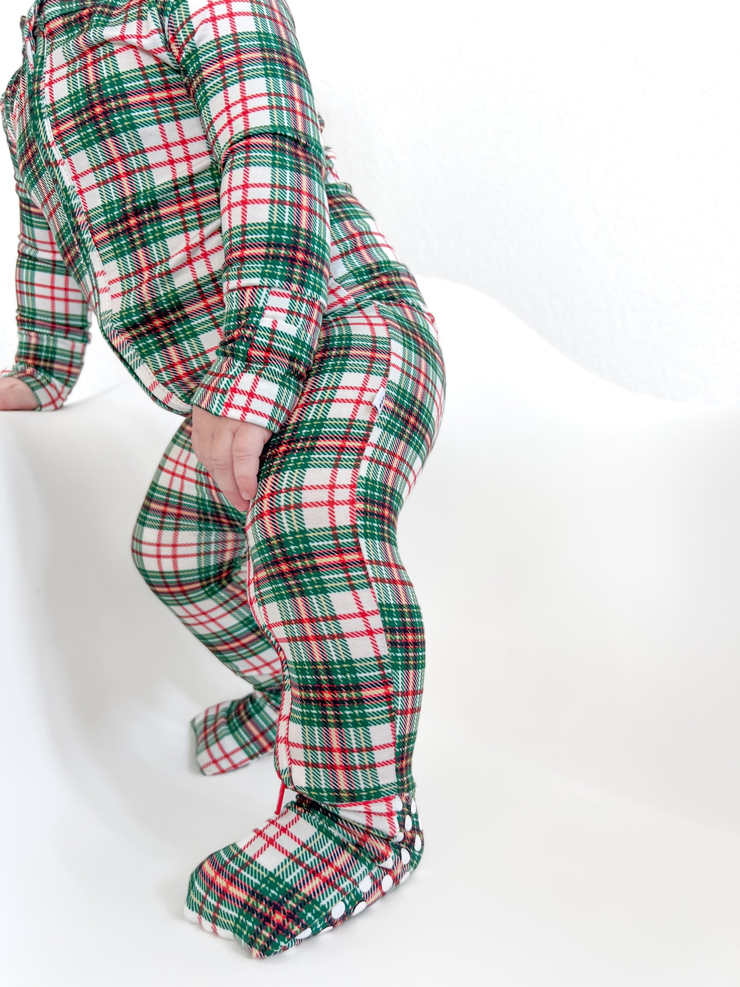 Cozy baby in a classic Christmas plaid print bamboo convertible zip romper, ready for holiday fun!