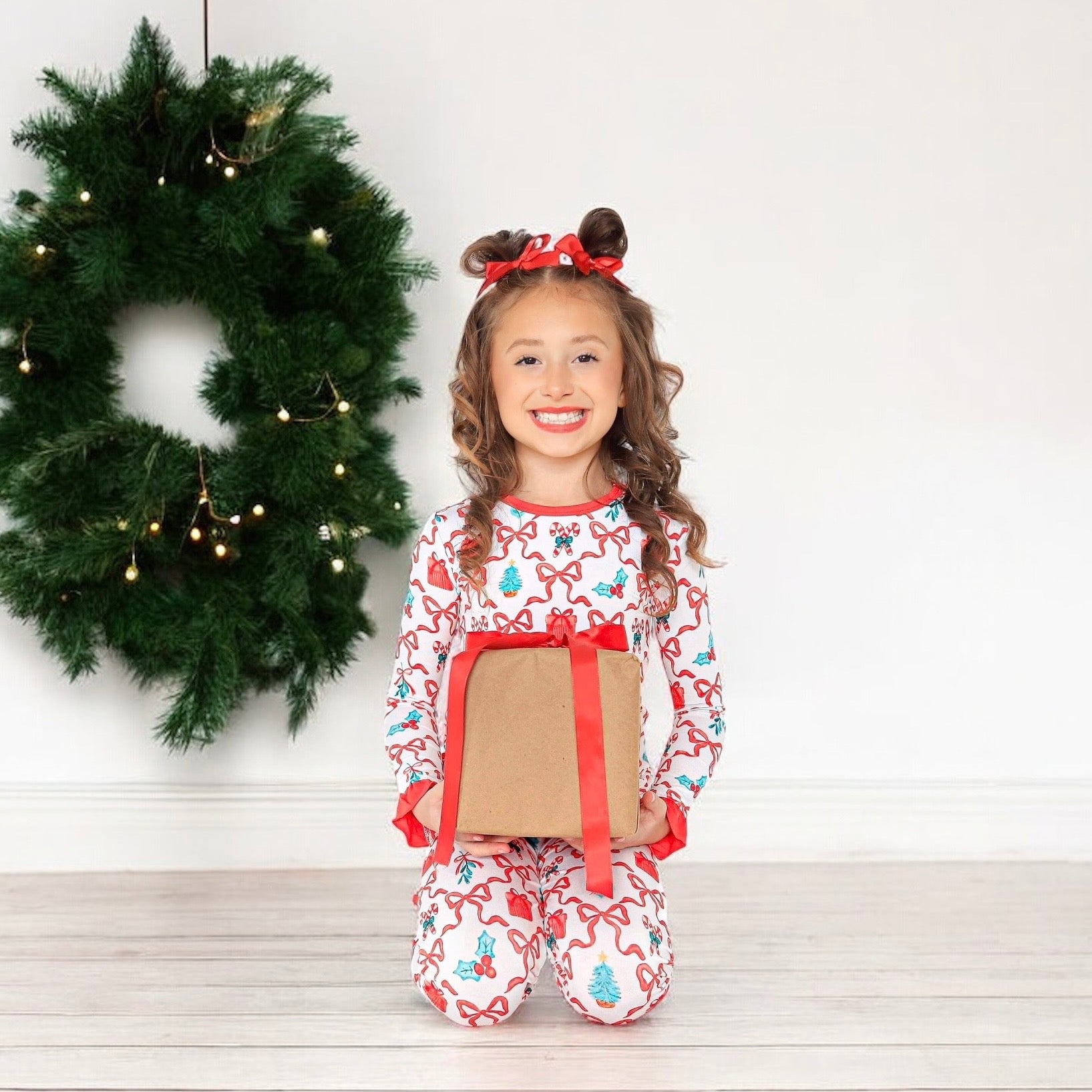 Soft and cozy two-piece bamboo set with ruffle cuffs, showcasing a festive Christmas print of bows and candy canes, perfect for celebrating the season.