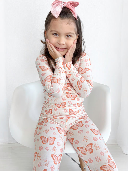 Girl wearing her bamboo pajamas with a dainty butterfly and floral print. Soft and cozy.